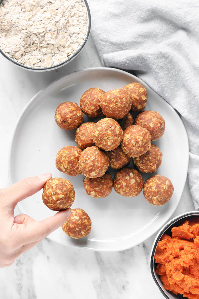 Crunchy Pumpkin Pie Energy Balls arranged in a pile on a white plate.