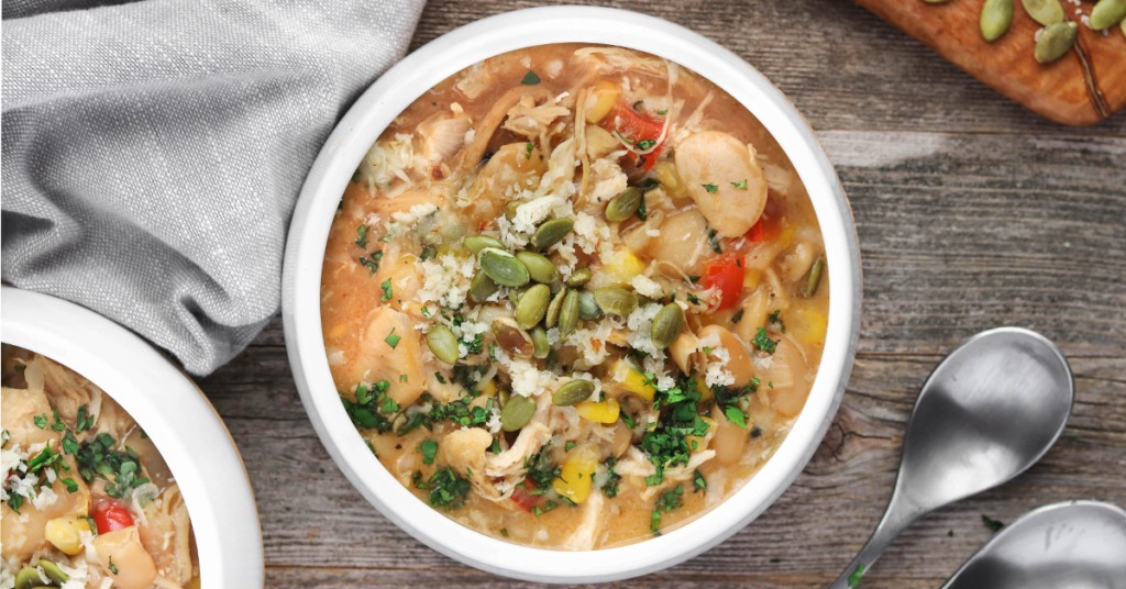 Hearty, 1-bowl White Chicken Chili has seasoned chicken, white beans, tons veggies and a creamy cornmeal base. Perfect served with a shredded Vermont White Cheddar, guacamole and corn chips.