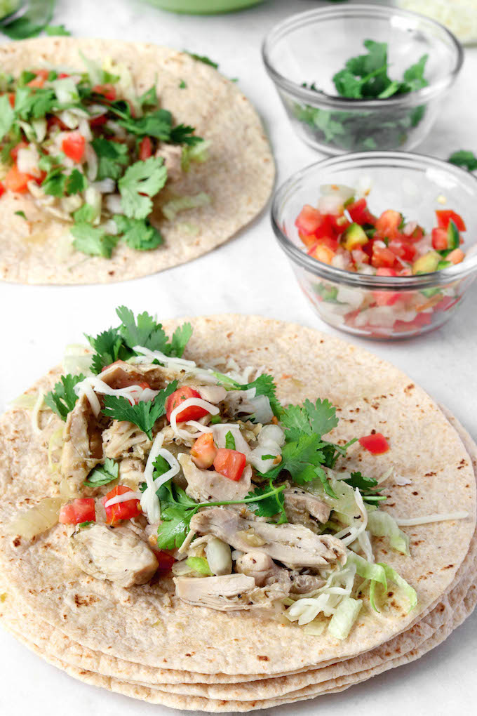 Easy, 4 Ingredient Salsa Verde Chicken Tacos with whole wheat tortillas, shredded cheddar, and spicy pico are healthy, filling and couldn't be simpler to throw together.