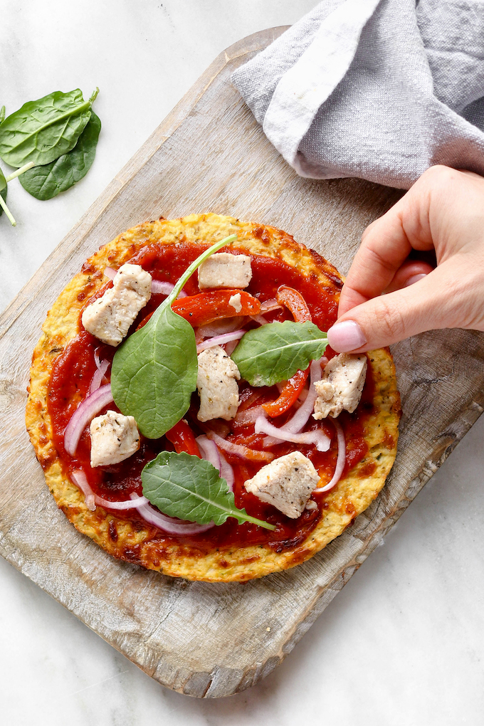 Simple Cauliflower Pizza Crust on a wooden cutting board.