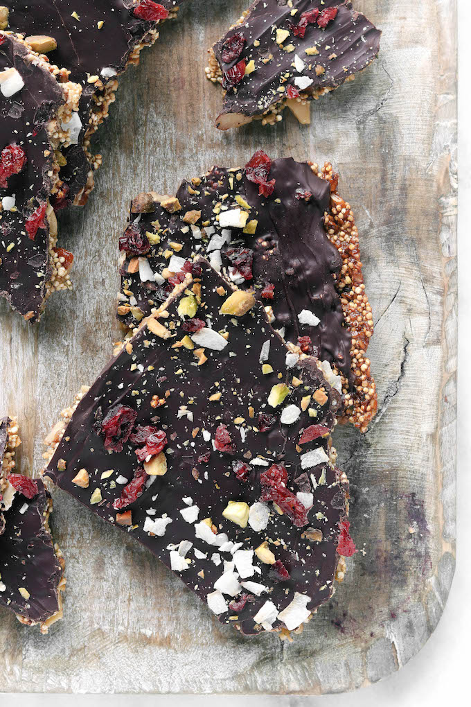 Superfood Dark Chocolate Quinoa Bark stacked on a wooden cutting board.