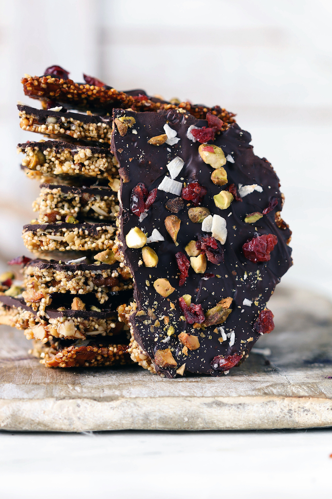 Superfood Dark Chocolate Quinoa Bark stacked on a wooden cutting board.