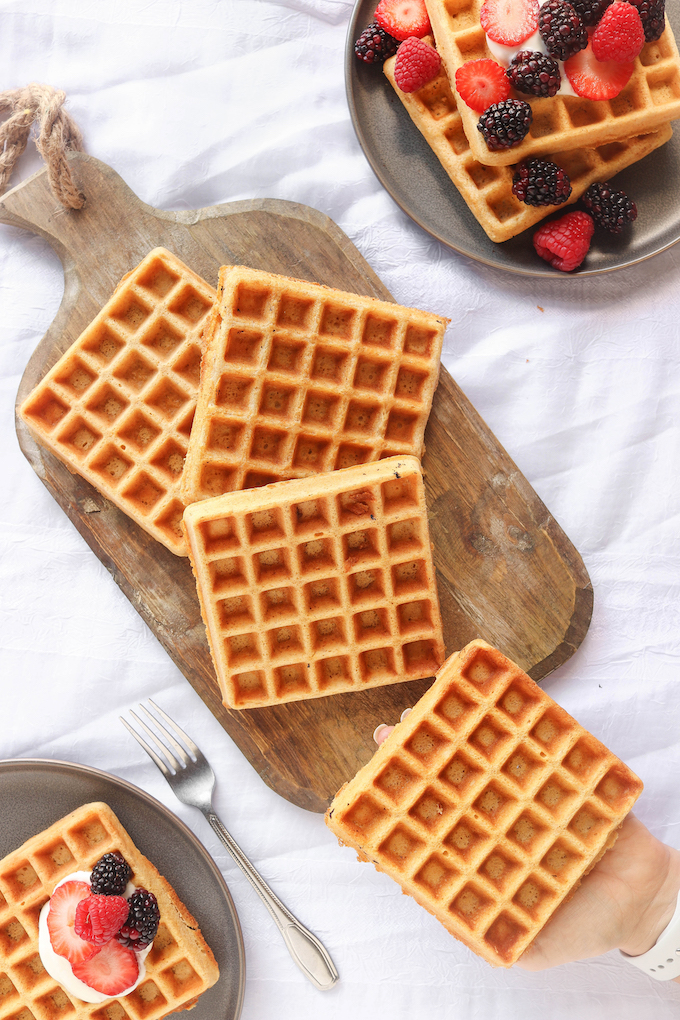 Belgian Spelt Waffles arranged on a wood cutting board.