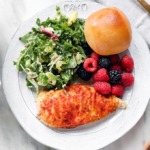 3-Ingredient Hummus Crusted Chicken on a white plate with brussel slaw and fresh berries.