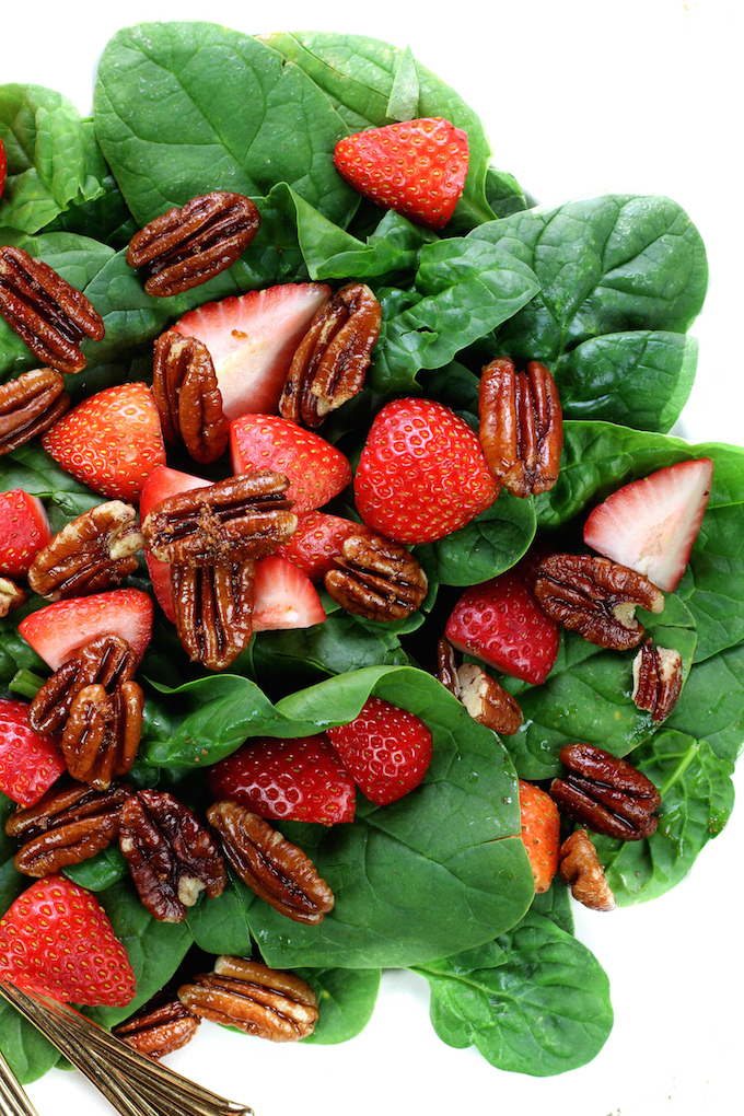 A simple spinach salad with loads of crunchy sweet pecans and fresh juicy strawberries, all dressed in a homemade tangy-sweet creamy vegan dressing.