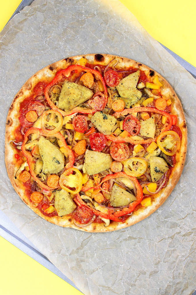 Homemade Veggie Pizza (V, GF) is made with an herby spelt-flour crust, simple tomato sauce, LOADS of sautéed veggies and topped with a "secret" ingredient.