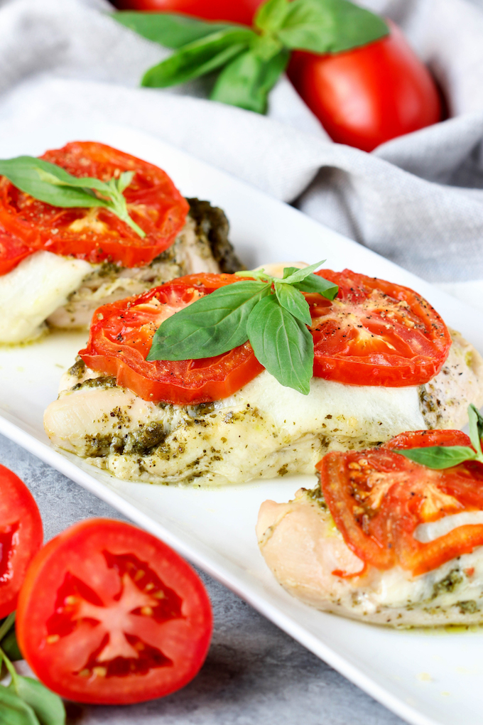 4 Ingredient Pesto Chicken Bake is healthy, simple,delicious and requires just 5-minutes prep. Juicy chicken topped with fresh pesto, melty mozzarella and topped with vine ripened tomatoes.