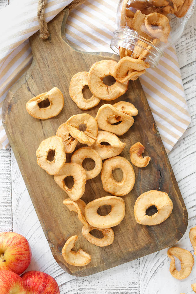 Homemade Apple Chips arranged on a wooden cutting board.