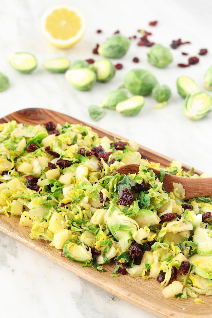 A healthy Cranberry Brussel Slaw loaded with fresh veggies, sweet apples and dressed in a simple lemon and olive oil dressing! Crisp, refreshing and comes together in 15 minutes.