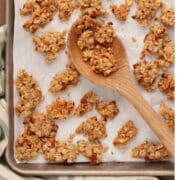 Quick Chunky Granola spread out out on a parchment covered sheet pan.
