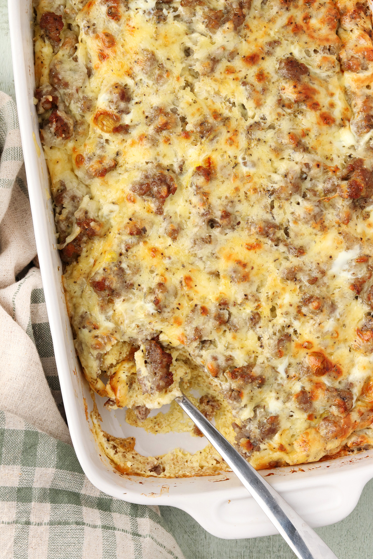 Sausage Egg Breakfast Casserole in a white dish. A slice is missing from the dish.