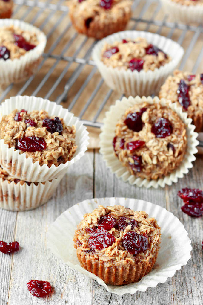 Cherry + Vanilla Baked Oatmeal Cups arranged sporadically on a baking rack and on a wooden surface.