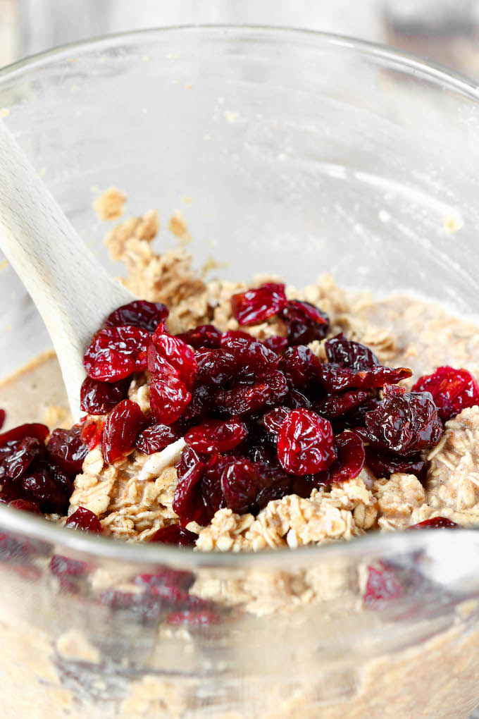 Cherry + Vanilla Baked Oatmeal Cups arranged sporadically on a baking rack and on a wooden surface.