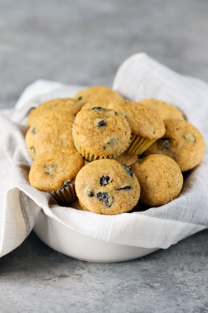 Perfect whole-food Mini Blueberry Corn Muffins made with 9 ingredients! Naturally sweetened, crumbly, tender and studded with bursts of juicy blueberry.