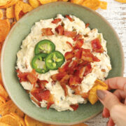 Slow Cooker Jalapeno Popper Dip with bacon surrounded by corn chips.