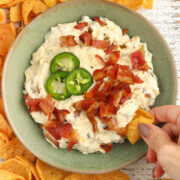 Slow Cooker Jalapeno Popper Dip with bacon surrounded by corn chips.