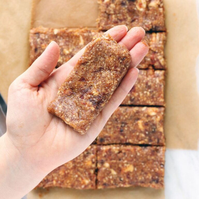 3-Ingredient Cashew Cookie Lara Bar being lifted from cutting board.