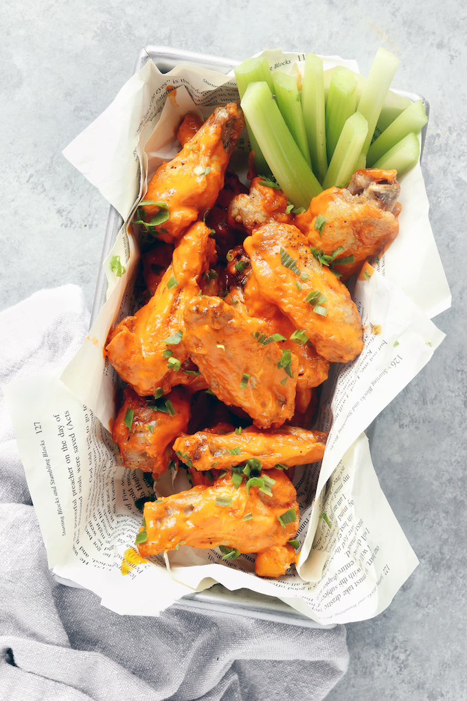 Extra Crispy Air Fryer Buffalo Chicken Wings in a silver basket lined with newspaper.