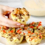 Baked Omelet Cups on a plate. A hand is picking up the one from the top center.