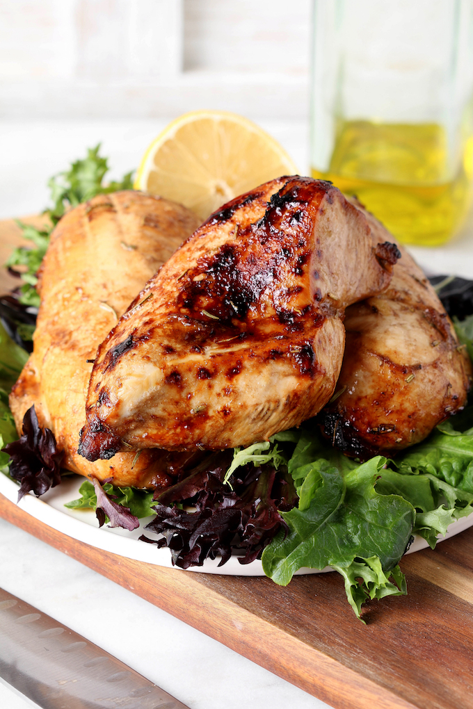 Simple Spiced Balsamic Chicken Breast on a plate of artisan lettuce.
