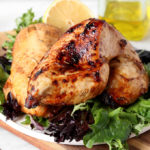 Simple Spiced Balsamic Chicken Breast on a plate of artisan lettuce.