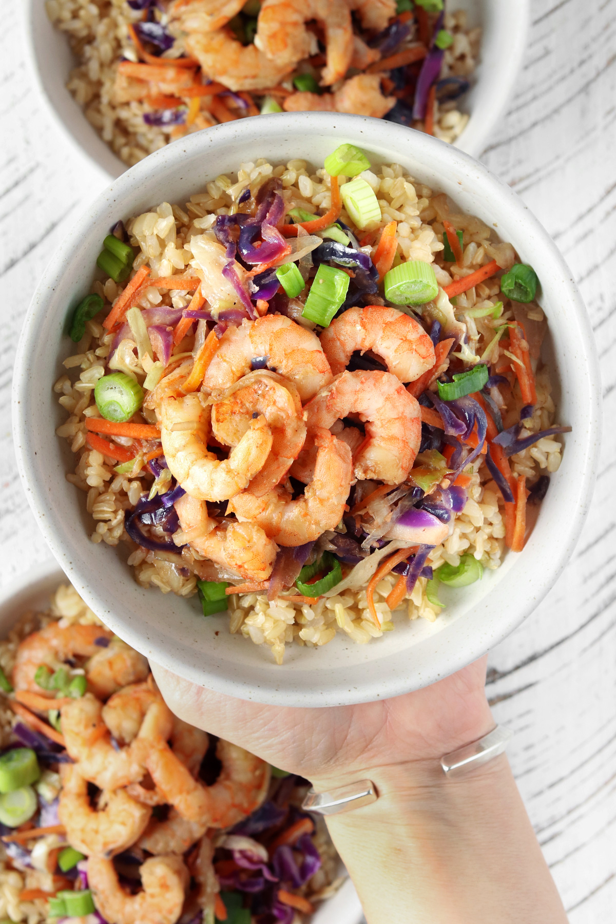 Shrimp Egg Roll In A Bowl in a white bowl being lifted from counter.