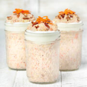 Carrot cake overnight oats in mason jars topped with carrots, yogurt and pecans.