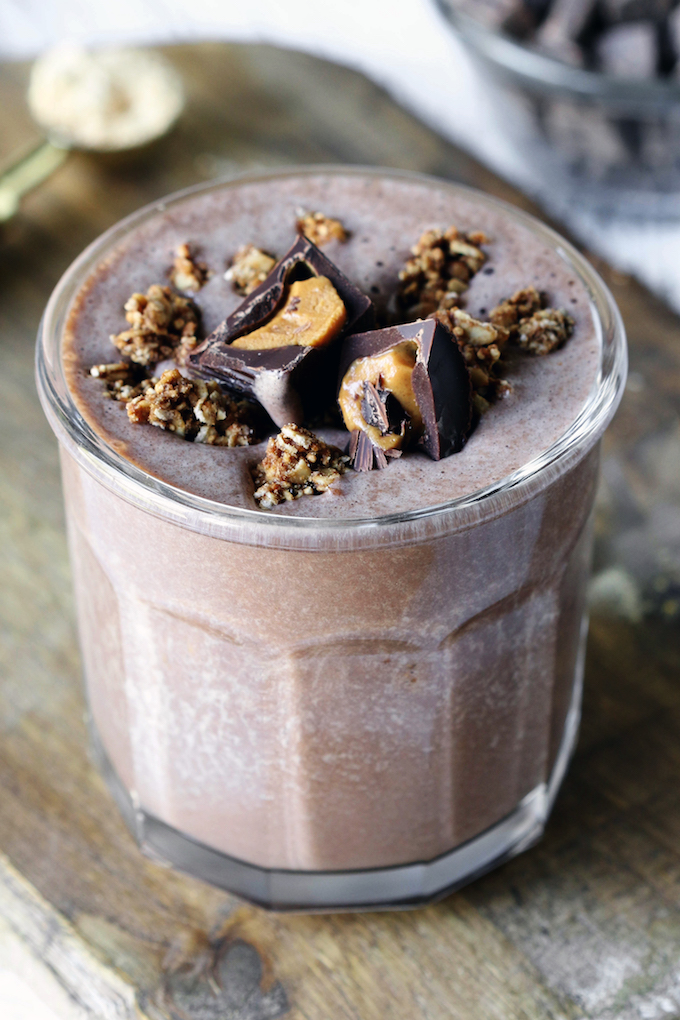 Peanut Butter Cup Protein Smoothie in a glass cup. It is garnished with granola and peanut butter cups.