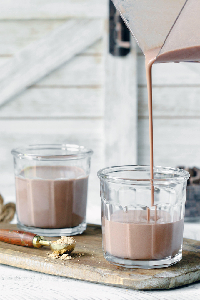 Peanut Butter Cup Protein Smoothies being poured into a glass cup.