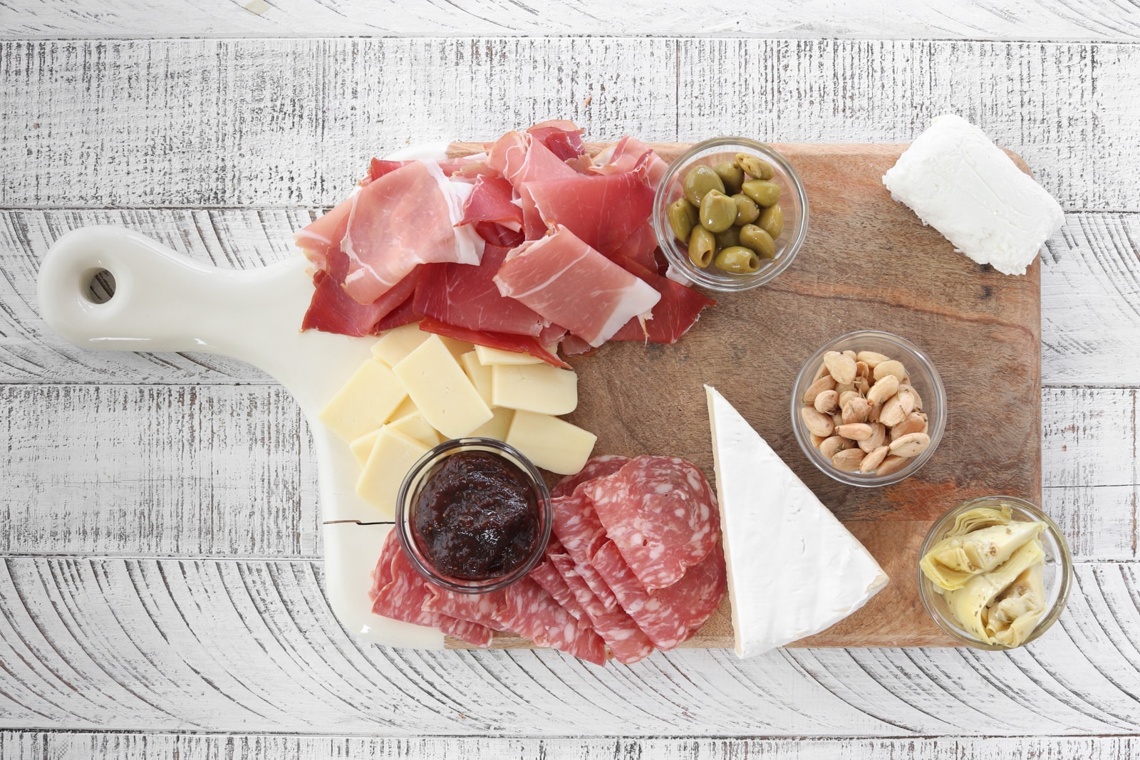 Step 4: Easy Charcuterie Board. Cutting board filled with marinated veggies, nuts, smoked meats and cheeses from Trader Joe's.