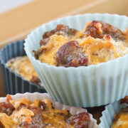 Close-up of sausage and cheese egg muffins in pastel silicone baking cups, ready to reheat.