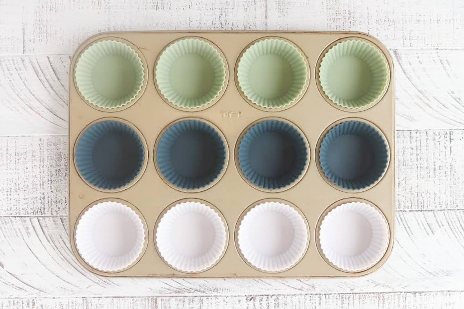 Silicone muffin liners in a gold muffin pan. 