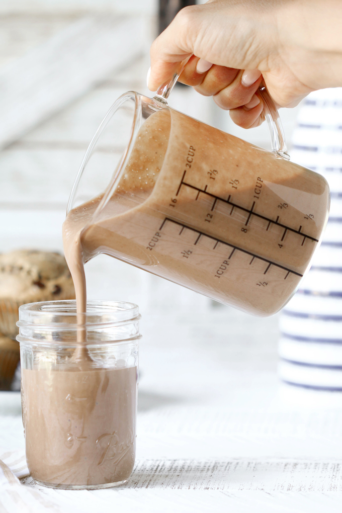 Get Up And Go Healthy Coffee Smoothie being poured from a measuring cup into a mason jar.