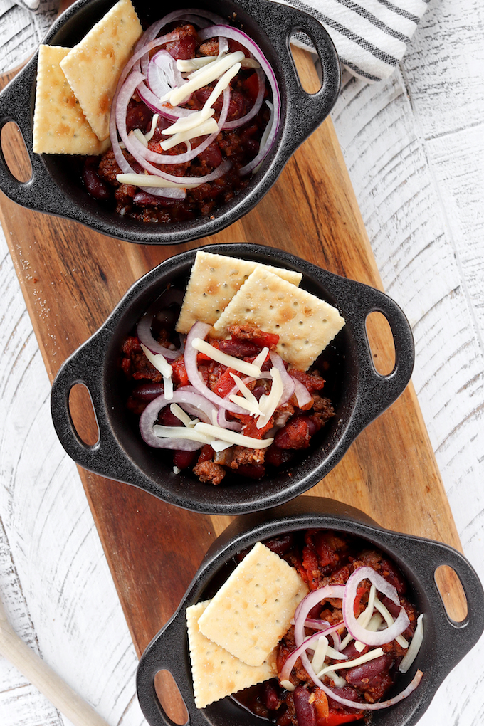 Easy Instant Pot Turkey Chili arranged in small black bowls on a wooden surface.