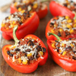 Freezer-Friendly Quinoa Stuffed Peppers on a parchment covered sheet pan.