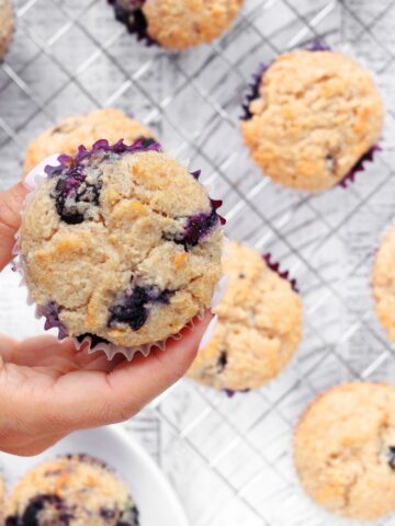 Blueberry Protein Muffin being picked up from a baking sheet.