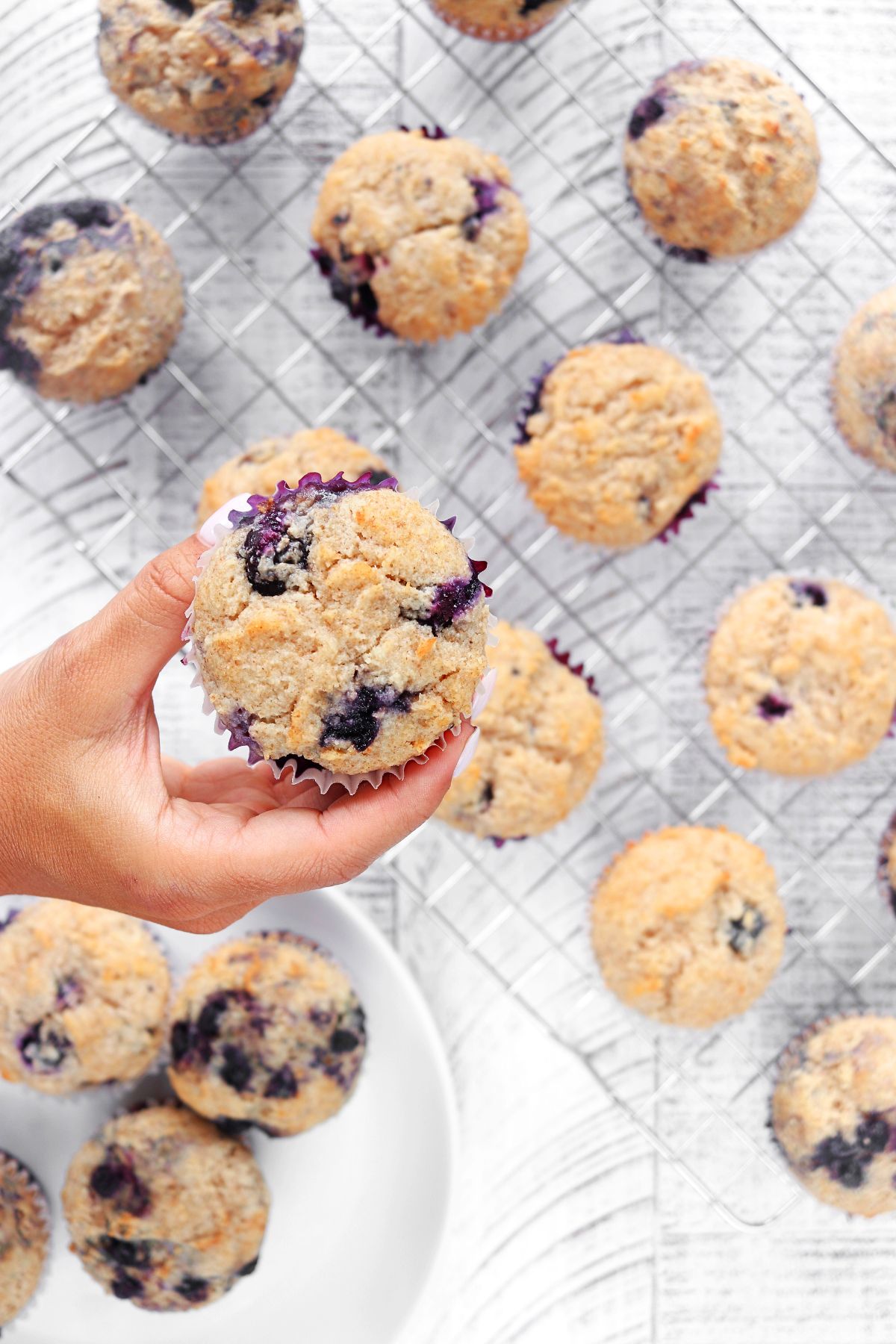 Blueberry Protein Muffin being picked up from a baking sheet.