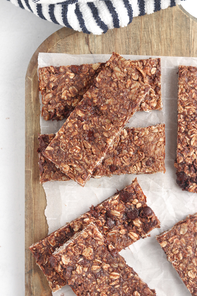 Overhead shot of Healthy Homemade Peanut Butter Chocolate Protein Bars arranged on a wood cutting board.