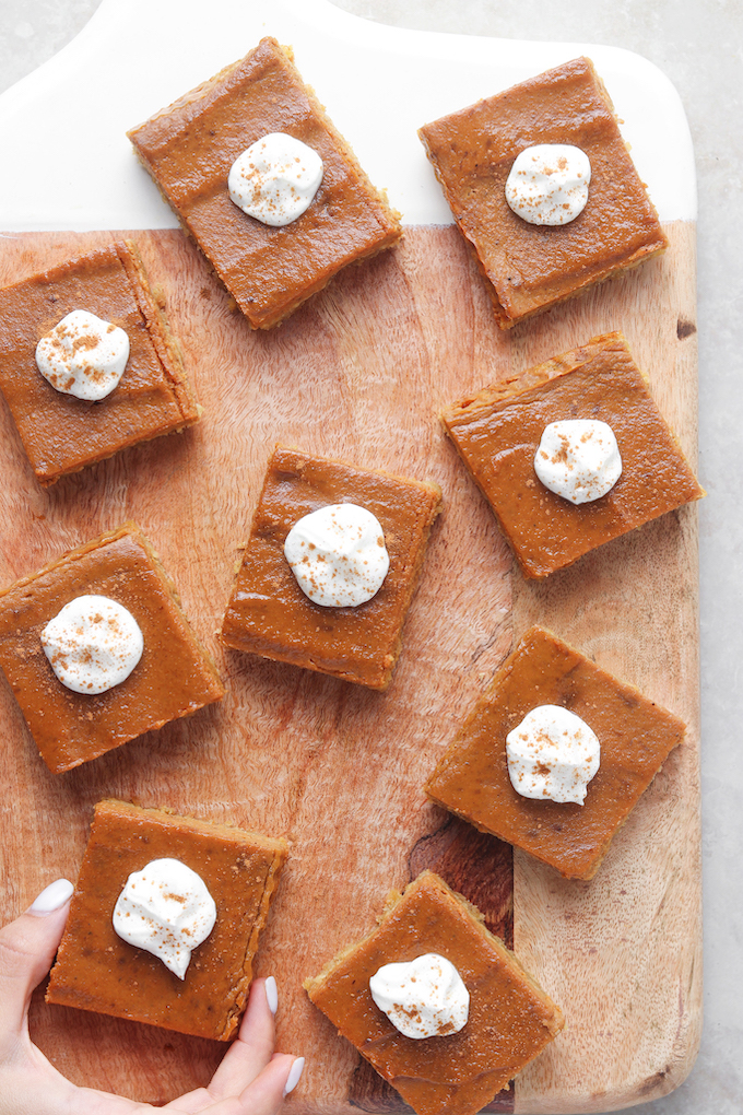 Healthy Pumpkin Pie Bars arranged on a wooden cutting board.