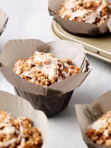 Close up shot of Gingerbread Muffins with Maple Glaze on a white countertop.