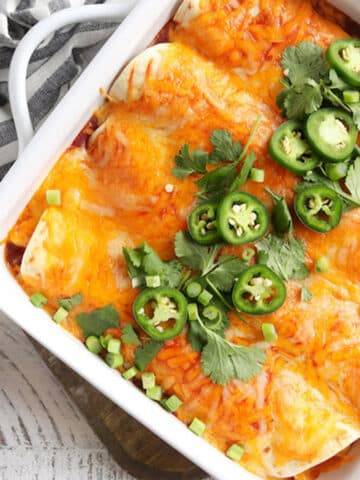 Easy Instant Pot Chicken Enchiladas garnished with jalapeños, green onions and cilantro.