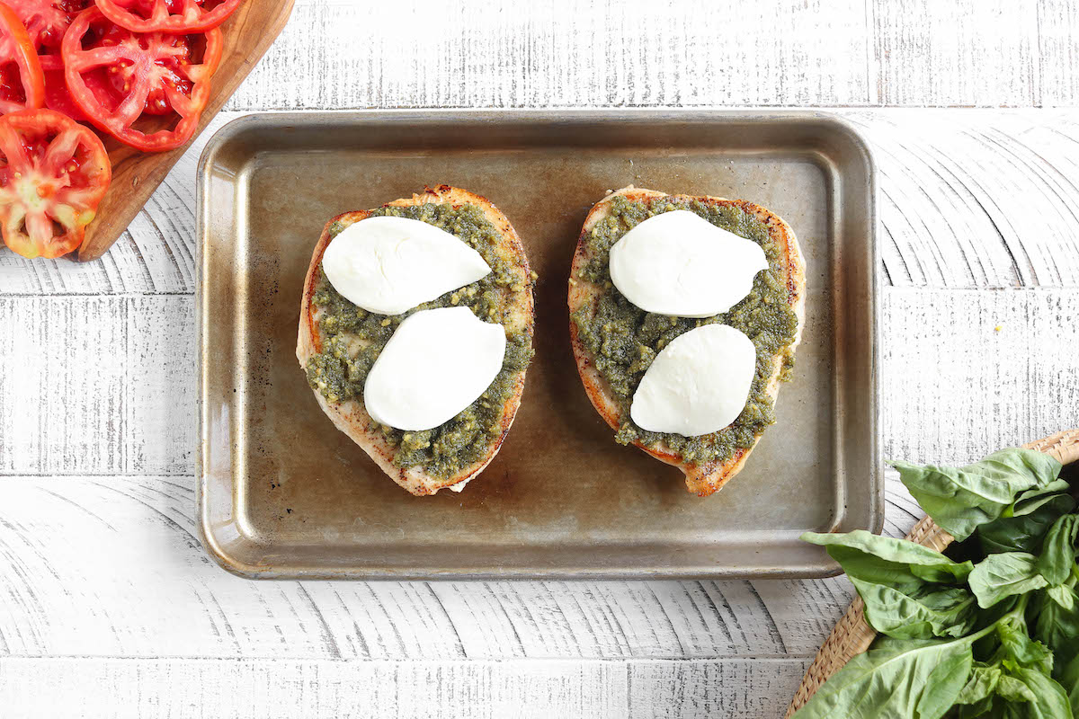 2 large chicken breasts topped with basil pesto and mozzarella cheese.