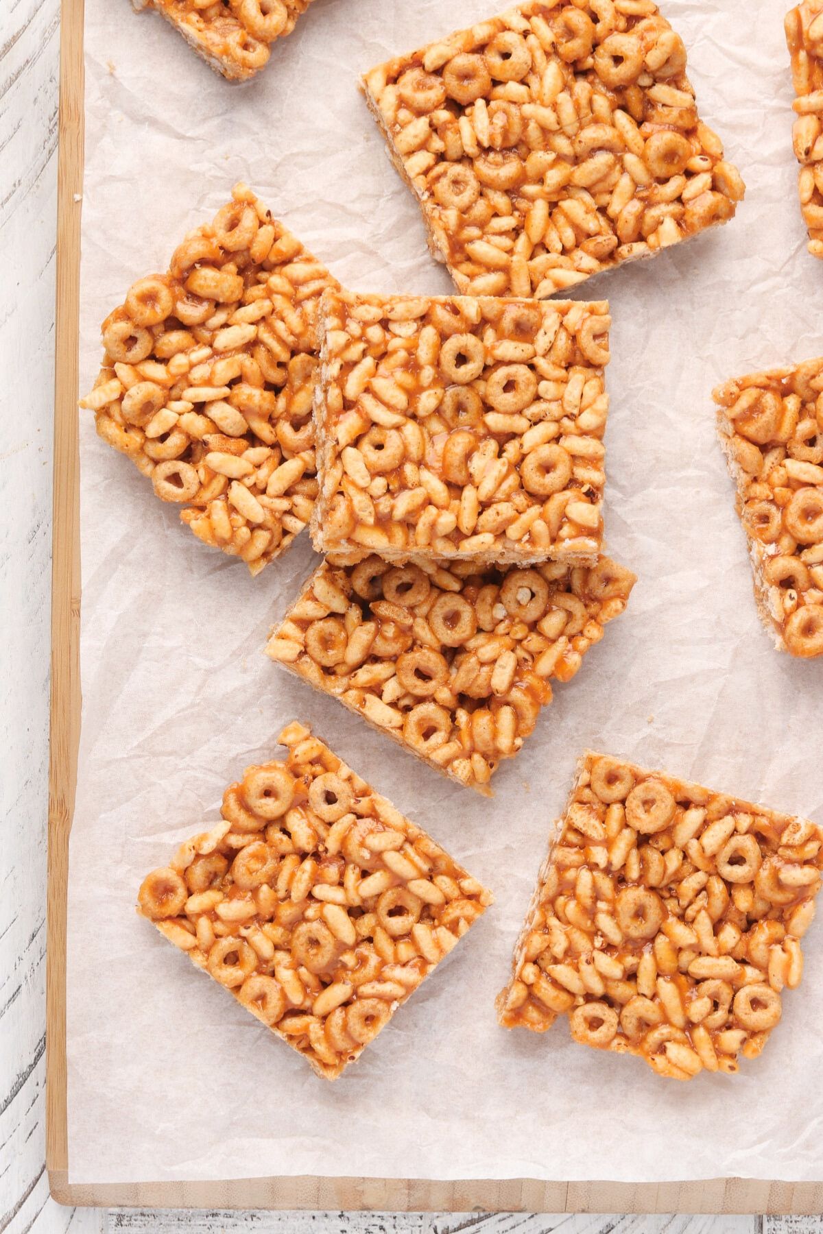 No bake cereal bars being served on a parchment paper covered serving board.