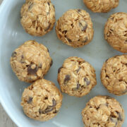 No-bake peanut butter oatmeal power balls with chocolate chips arranged on a light blue plate.