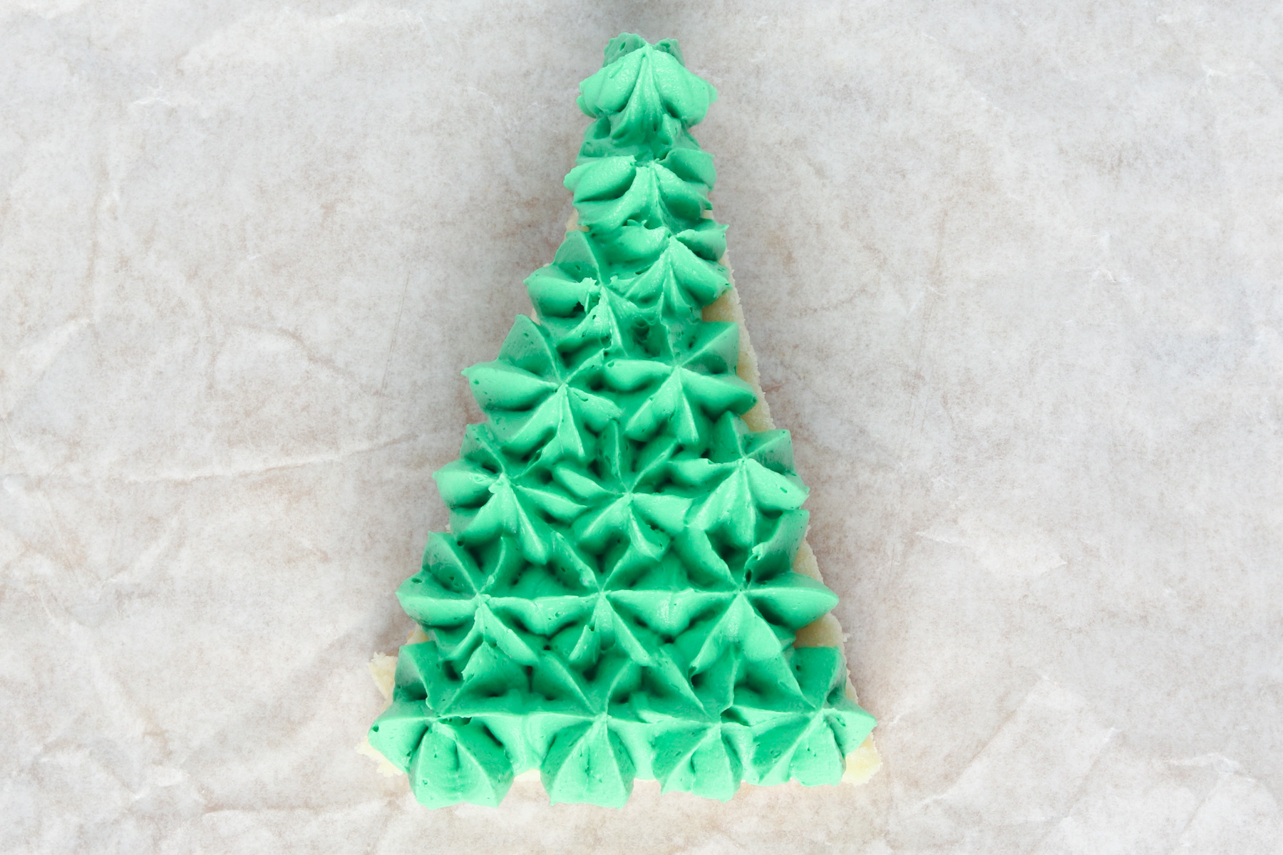 Step 9: Christmas Tree Sugar Cookies. Pipe small stars onto the surface of the cookie bar.