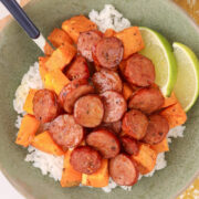 Honey-lime chicken sausage bowl with roasted sweet potatoes, white rice and lime wedges, served with honey-lime dressing.