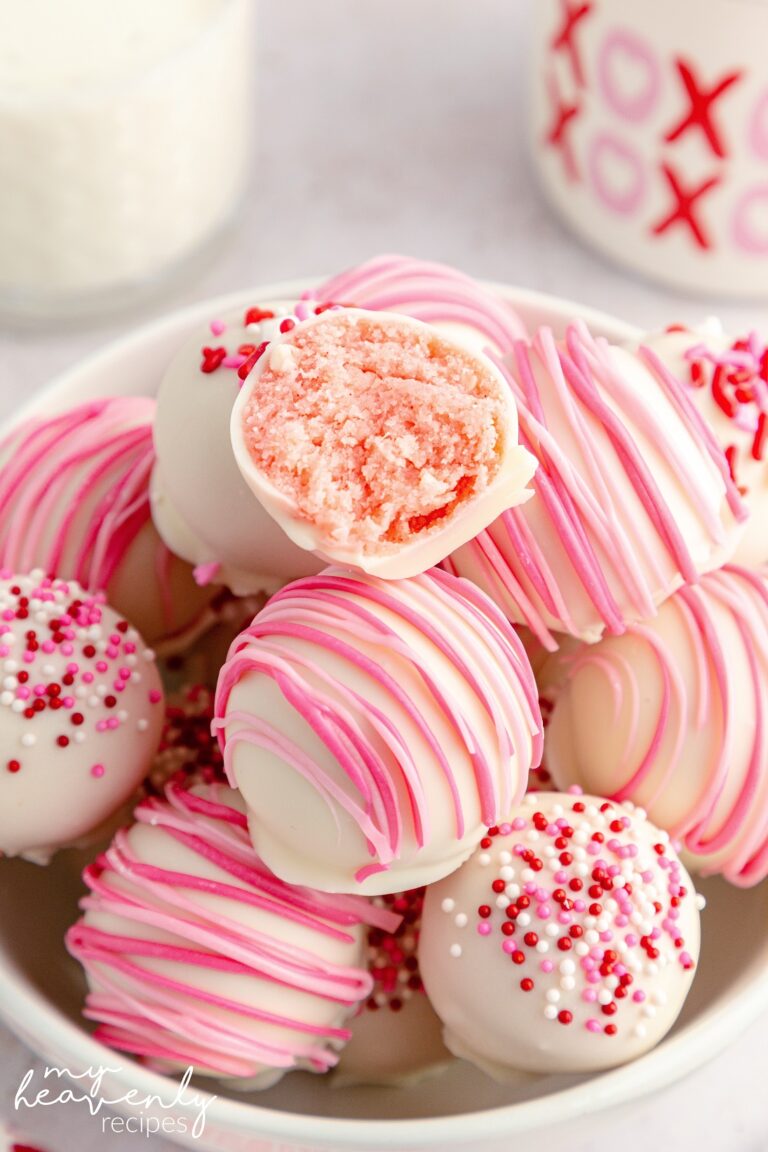 Strawberry Cake Truffles dipped in white melting chocolate and topped with pink and red icing.