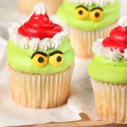 Grinch cupcakes on a white countertop.