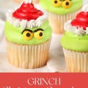 Grinch cupcakes on a white countertop.