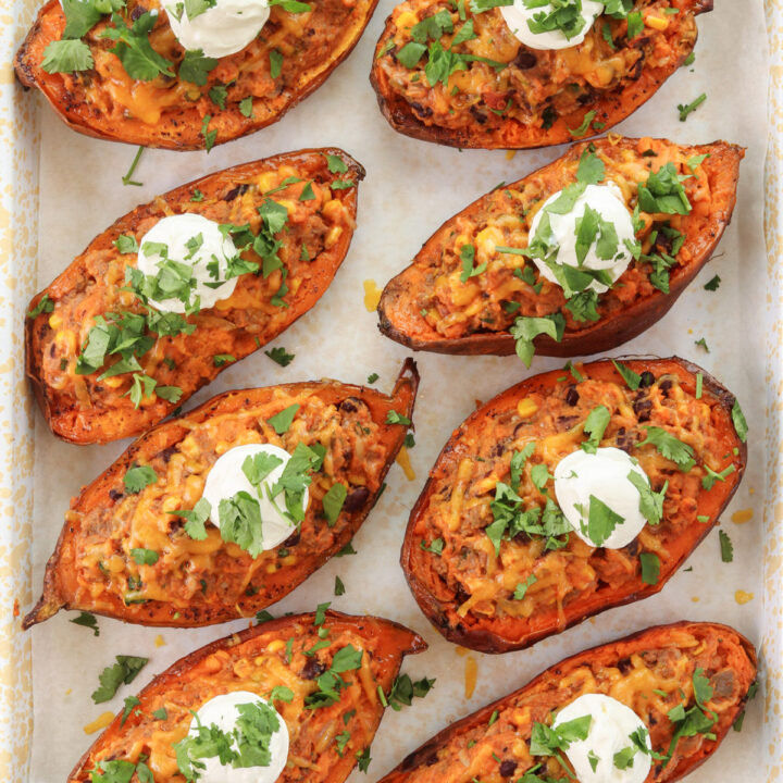Loaded Mexican sweet potatoes stuffed with ground beef, black beans, corn, and cheese, topped with sour cream and cilantro.